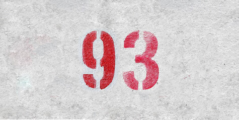 Red Number 93 on the white wall. Spray paint.