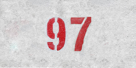 Red Number 97 on the white wall. Spray paint.