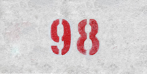 Red Number 98 on the white wall. Spray paint.