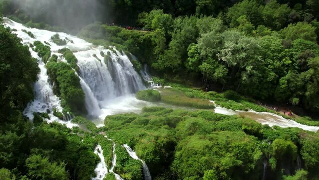 Italy Marmore Waterfall Aerial 4K Drone Flight Rising Over Cascading Falls to Historic Town on Hilltop Scenic Rainbow and Powerful Water Tiers in Umbria Terni Biggest Artificial Waterfall Europe