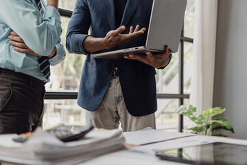 Naklejka premium Businessman and businesswoman are in a working meeting with many financial documents on the table. There is busy business profit analysis and brainstorming in the office. Close-up pictures