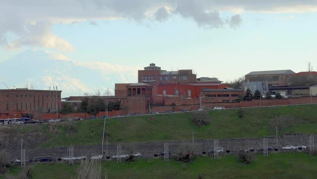 Urban panorama of Athens street traffic with red tuf stone buildings in spring Yerevan, under a cloudy sky, with snow-capped Mount Ararat in the background. Atmospheric cityscape, uhd, 4k, 3840, 2160