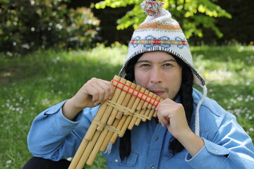 Native American man playing a wooden flute 