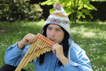 Native American man playing a wooden flute 