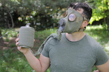 Man wearing vintage gas mask in natural setting 