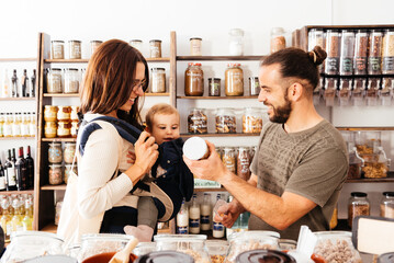 Storekeeper Assisting Mother and Child at a Zero-Waste Grocery Store During Daytime Shopping