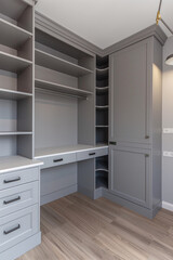 Fototapeta premium A grey and white wardrobe with shelves, light gray walls, neutral colors, modern design, light wood floor