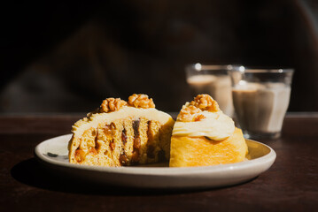 Sliced homemade mixed fruit cinnamon roll with cream cheese frosting and walnuts on top on a ceramic plate