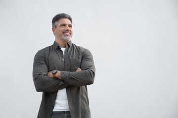Handsome senior grey haired business man standing proudly with crossed arms on isolated white...