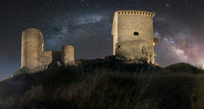 Panoramic night view of the ruins of the castle of Santa Gadea del Cid, Burgos framed by the Milky Way in a starry sky