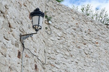 Antique lantern lamp on the stone wall outside. Nostalgic vintage background with copy space