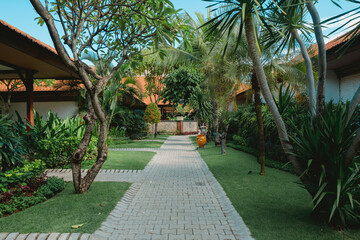 Balinese resort with pavement pathway through tropical garden