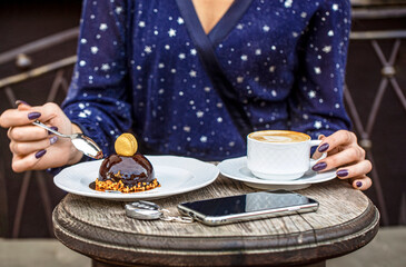 Girl coffe time. Coffee or coffe cup at cafe in the morning. Woman in hand Cup of fresh cappuccino. Chocolate cake. Closeup. Cappuccino in a cup, hot latte, delicious coffee