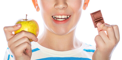 Healthy food, good teeth. Bad food bad teeth. Little boy holding an apple and a chocolate in her...