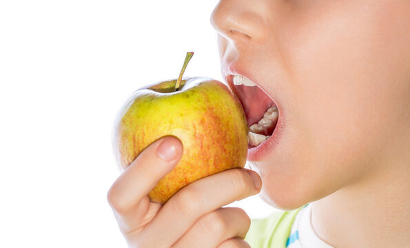 Closeup child biting red apple over white background. Side view. Little boy smiling happy eating green apple. Healthy food, good teeth. Close-up view healhty child's teeth, apple. Child eating apple