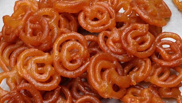 Fried Jalebi dipped in sweet syrup. Jalebi dipped in sweet syrup is ready to serve. Jalebi making the recipe.