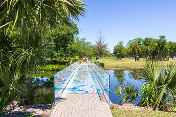 A colorful footpath surrounded by lush green trees, grass and plants in the Sculpture Garden at New...