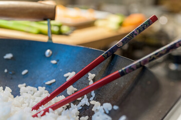 Wok with white rice and decorated Chinese chopsticks