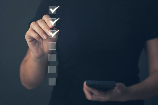 Businessman uses his mouth to check boxes in the document list Concept of online verification form Checklist process sequence The business reviews the job details and ticks the evaluation.