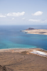 Views of the island of La Graciosa from the viewpoint of El Rio. Turquoise ocean. Blue sky with big white clouds. Caleta de Sebo. Town. volcanoes. Lanzarote, Canary Islands, Spain