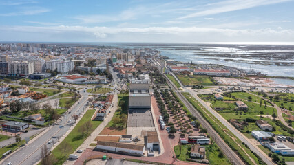 Fototapeta premium The Portuguese oceanfront city of Faro overlooking a theater, filmed with a drone. Ria Formosa in background. Algarve.