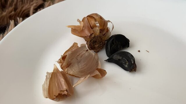 Black fermented garlic on a white plate