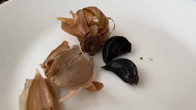 Black fermented garlic on a white plate