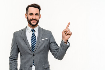 Cheerful Caucasian manager in grey suit pointing at free space isolated over white background. Advertising concept, man showing copyspace blank space, promotion