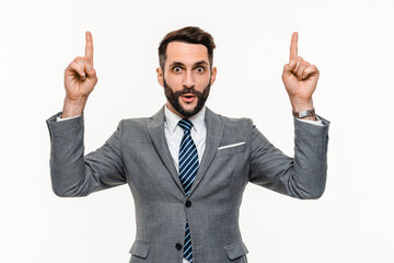 Happy handsome businessman showing upwards with fingers on copyspace isolated over white background. Successful young manager lawyer clerk pointing on discount sale promotion offer