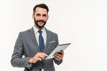Cheerful Caucasian businessman typing on digital tablet remotely isolated over white background....