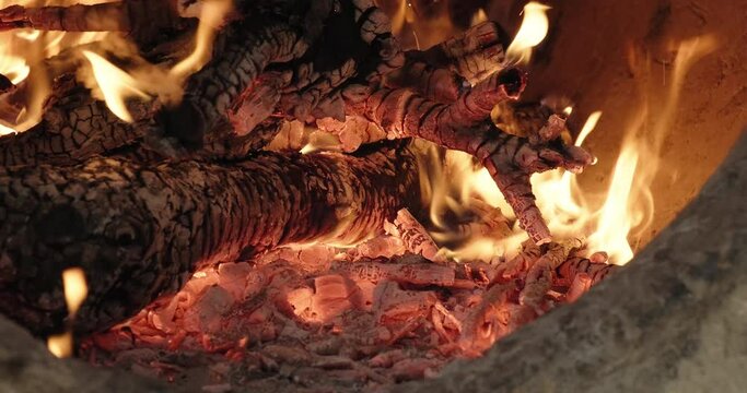 Tandoori roti bakery. Burning fire in a traditional Indian clay oven tandoor. Close-up