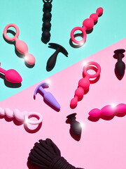 sex toys background. anal plugs and dildo over pink backdrop - obrazy, fototapety, plakaty