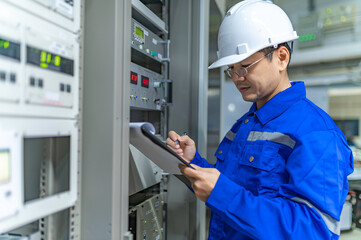 Electrical engineer woman checking voltage at the Power Distribution Cabinet in the control...