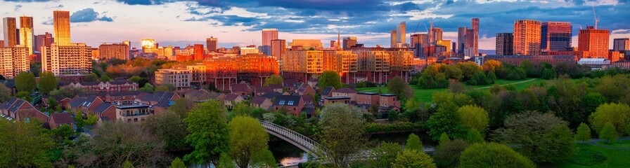Panoramic aerial image of Salford and Manchester skyline and a footbridge crossing river Irwell 