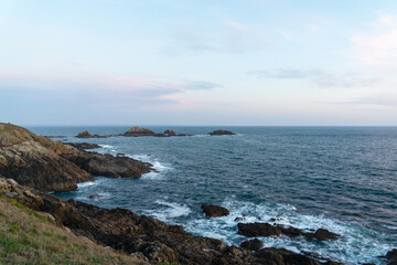 Falaises rocheuses et îlot rocheux façonnent la côte sauvage de la Pointe Saint-Mathieu, où le ressac rencontre la majestueuse mer d'Iroise, un paysage saisissant de la Bretagne.