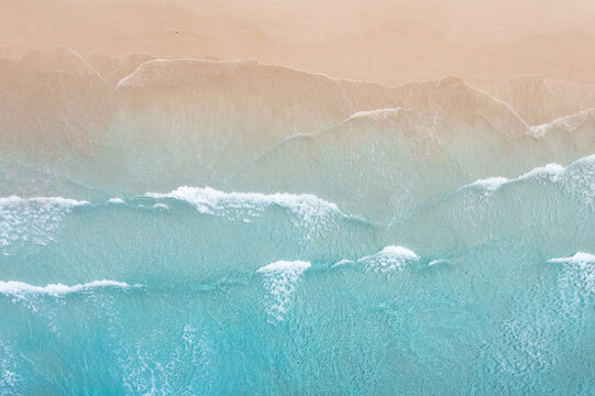 Ocean waves breaking onto a beach. Sandy clean coast.