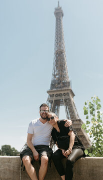 Smiling couple in front of the Eiffel Tower