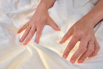 A pair of hands touching and feeling a comfy bed spread cotton duvet. Great night sleep and comfort...