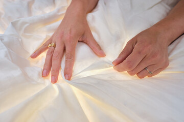 A pair of hands touching and feeling a comfy bed spread cotton duvet. Great night sleep and comfort...