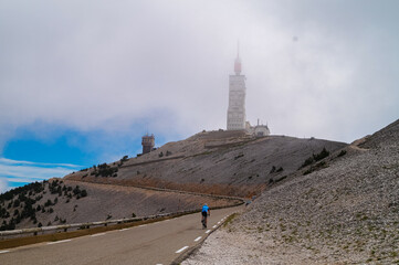 Rear view of cyclist going to the top of Mount Ventoux surrounded by mystical fog in Provence...