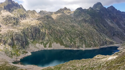 Panoramic view of glacier lake Lac du Basto in the Mercantour National Park in the Valley of Marvels near Tende, Provence-Alpes-Côte d'Azur Alpes-Maritimes, France. High mountain ridges in French Alps