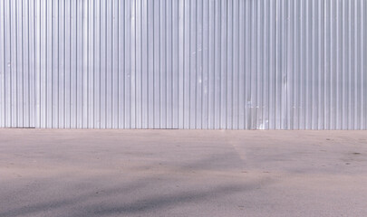 grey metal fence wall and asphalt