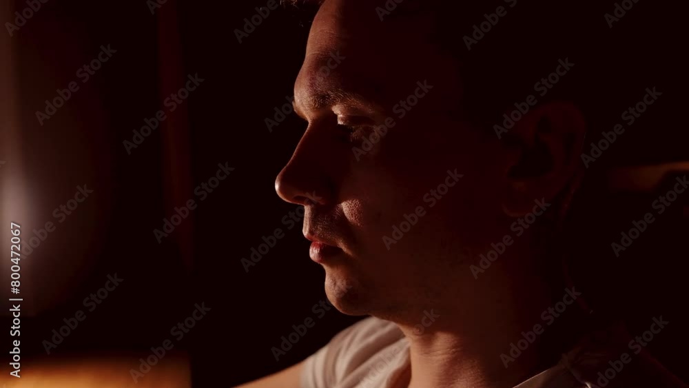 Canvas Prints a close-up of a young male programmer looking at a screen in a dark room.