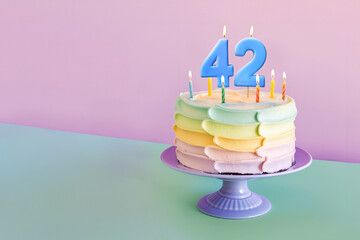 42nd birthday cake celebrating 42 years on an isolated, colorful pastel background.