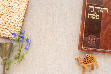 Jewish holiday Pesach (Passover) celebration concept. Book with text in Hebrew: 