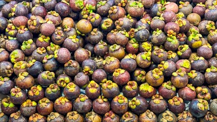 Fruit backdrop with densely packed mangosteen fruits at a market, highlighting the allure of tropical foods rich in nutrients, favored in modern health-conscious food culture. Healthy food