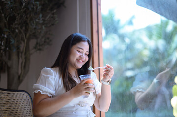 Morning Coffee in the Kitchen: A woman, smiling, enjoys her Dessert Cup in a sunny park