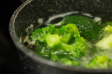 fresh broccoli in boiling water in a pan, healthy healthy food, top view