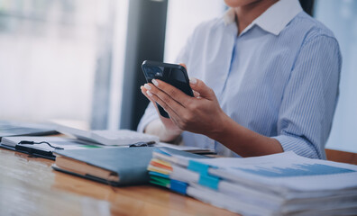 Portrait of a happy Asian businesswoman using mobile phone indoor, Asian businesswoman working in modern office.