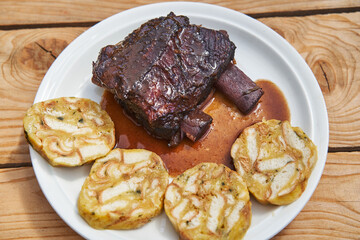 Close up picture on the slowly roasted beef ribs in the red wine and vegetables with delicious carlsbader style bread dumplings. Traditional tender and tasty specialty from cuisine of Czech republic.